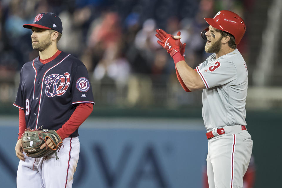 WASHINGTON, DC - APRIL 02: Bryce Harper #3 of the Philadelphia Phillies celebrates in front of Brian Dozier #9 of the Washington Nationals after hitting an RBI single during the sixth inning at Nationals Park on April 2, 2019 in Washington, DC.  (Photo by Scott Taetsch/Getty Images)