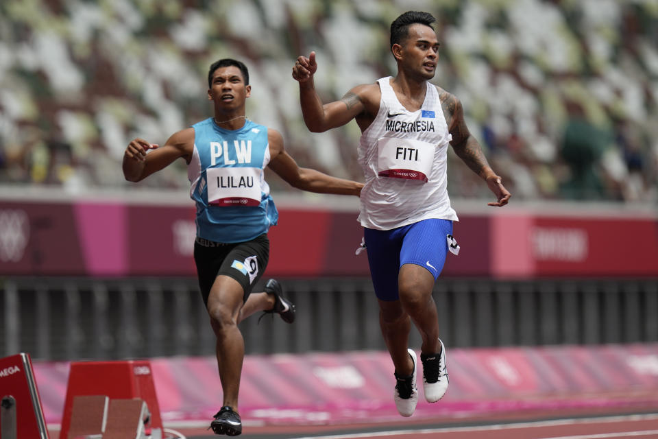 Adrian Ililau, of Palau, and Scott Fiti, of Federated States of Micronesia, compete in a heat in the men's 100-meter run at the 2020 Summer Olympics, Saturday, July 31, 2021, in Tokyo. (AP Photo/Petr David Josek)