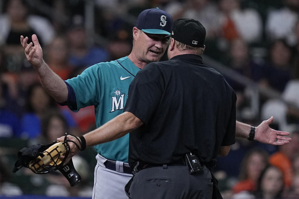 Seattle Mariners manager Scott Servais, left, argues with umpire Bruce Dreckman, right, after Dreckman called Ty France out on batter interference during the eighth inning of a baseball game against the Houston Astros, Saturday, Aug. 19, 2023, in Houston. (AP Photo/Kevin M. Cox)