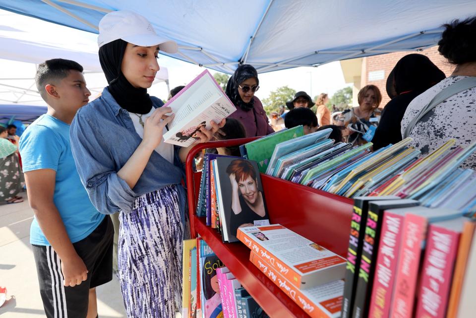 Zahra Al Juhishi, from Iraq, looks at books during Refugee Back to School Night at Granite Park Junior High in South Salt Lake on Monday, Aug. 7, 2023. | Kristin Murphy, Deseret News