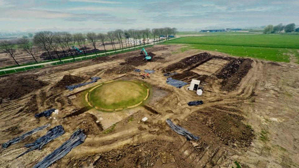 A bird's-eye view of excavation site with the large burial mound highlighted with a virtual grass overlay.