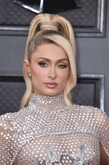 Paris Hilton wearing a high ponytail and a silver sequined dress