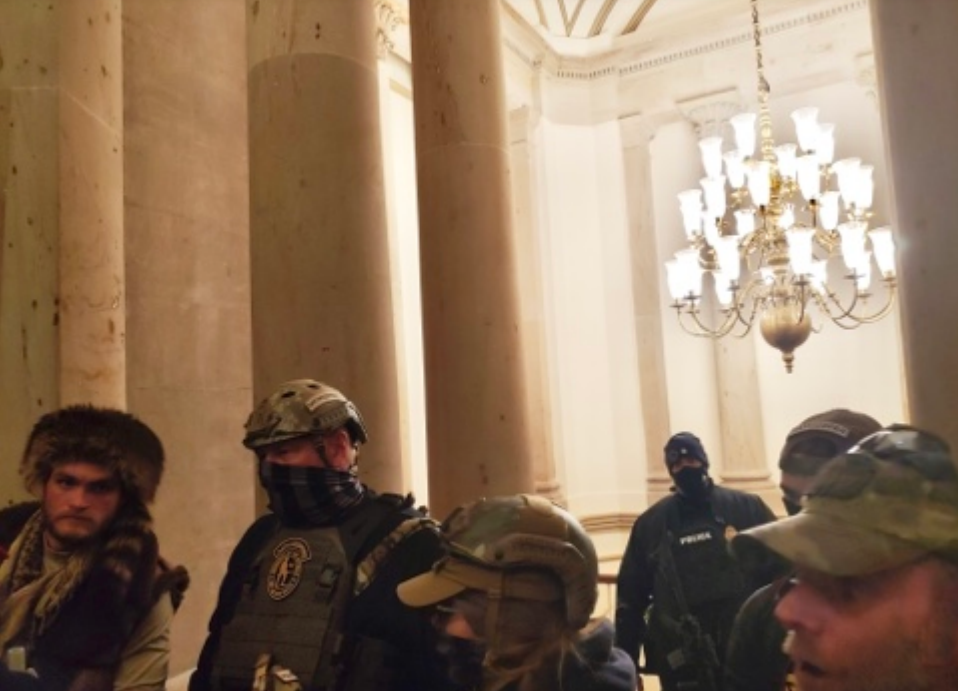 U.S. Capitol Police officer Harry Dunn stands behind members of the Oath Keepers on Jan. 6, 2021 during the Capitol attack.