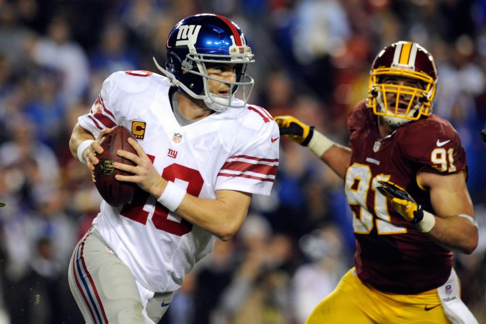 Quarterback Eli Manning #10 of the New York Giants scrambles as he is being chased by Ryan Kerrigan #91 of the Washington Redskins in the third quarter against the Washington Redskins at FedExField on December 3, 2012 in Landover, Maryland. (Photo by Patrick McDermott/Getty Images)