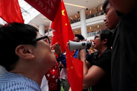 Pro-government and anti-government supporters chant against one another at a shopping mall in Hong Kong