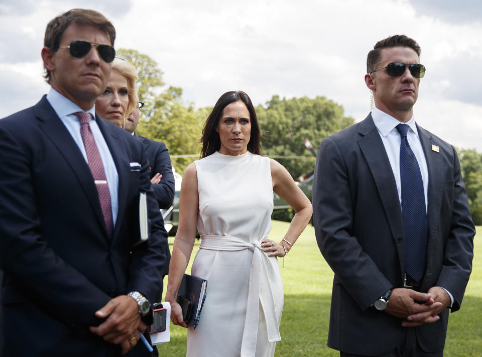 FILE - In this July 24, 2019 file photo, from left, White House deputy press secretary Hogan Gidley, Counselor to the President Kellyanne Conway, White House press secretary Stephanie Grisham, and a member of the Secret Service, stand together as President Donald Trump speaks to members of the media at the White House in Washington. Grisham is leaving her post after never holding a single press briefing. Grisham will be assuming a new role as chief of staff to first lady Melania Trump. (AP Photo/Carolyn Kaster)