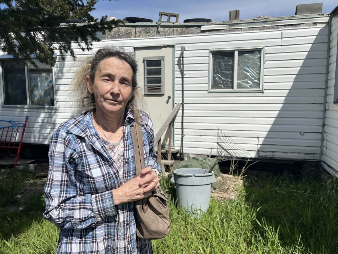 Cherylle Douglas pictured near her mobile home in Merritt, B.C., near the Coldwater River. She says her home is condemned by the flood damage it sustained last November. (Brady Strachan/CBC - image credit)