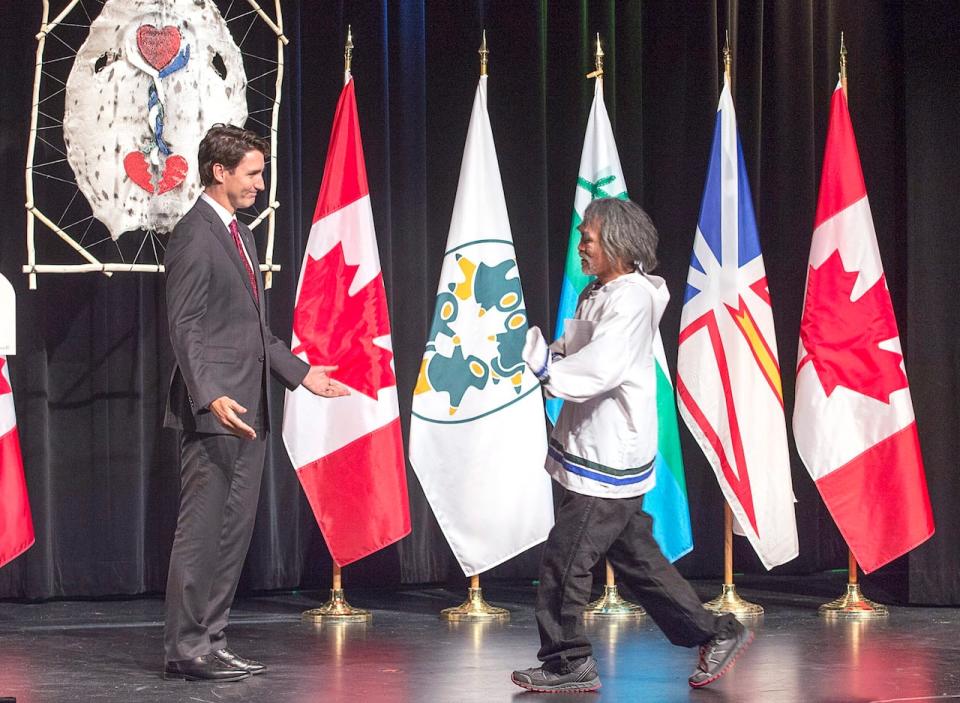 Prime Minister Justin Trudeau welcomes residential survivor Toby Obed to the stage after delivering an apology on behalf of the Government of Canada to former students of the Newfoundland and Labrador residential schools.