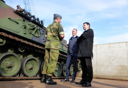 Colonel Eystein Kvarving, chief spokesman at the Norwegian Armed Forces Headquarters media centre (L) chats with Norwegian Justice Minister Tor Mikkel Wara (R) and Defense Minister Frank Bakke-Jensen after German military equipment was unloaded at Fredrikstad, Norway, September 7, 2018. REUTERS/Gwladys Fouche