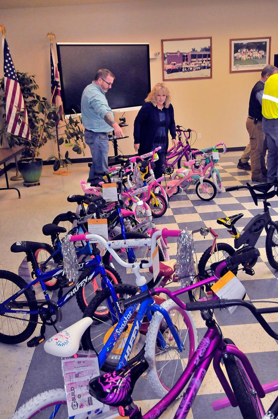TJ Shamp (left) and Pam Brown organize assembled bikes before delivering them to the Fraternal Order of the Police and OneEighty.