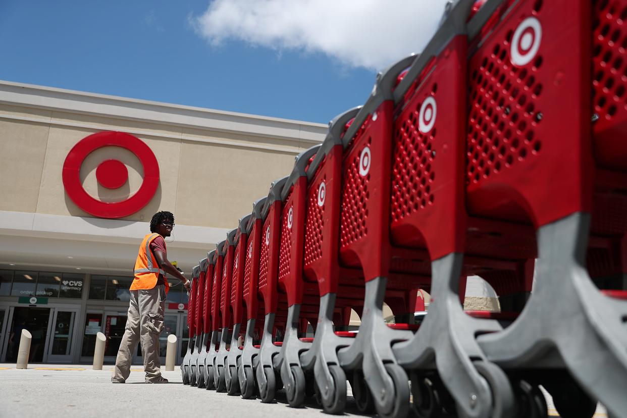 A Target worker moving shopping carts into a store