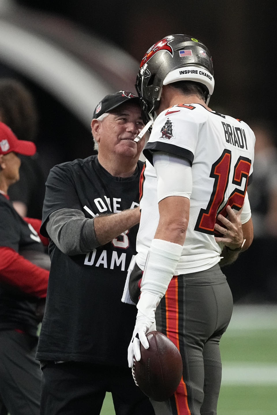 Atlanta Falcons defensive coordinator Dean Pees speaks with Tampa Bay Buccaneers quarterback Tom Brady (12) before an NFL football game Sunday, Jan. 8, 2023, in Atlanta. Pees announced his plans to retire Monday, Jan. 9, 2023. (AP Photo/John Bazemore)
