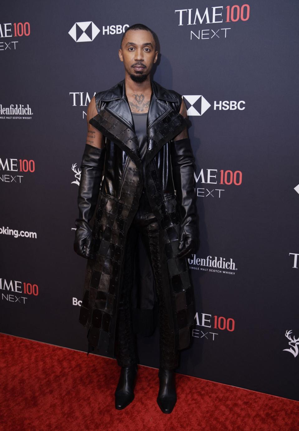 George in a detailed leather coat posing on the red carpet