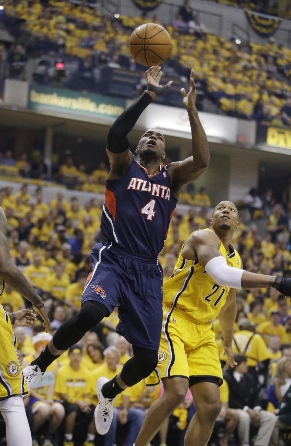 Atlanta Hawks' Paul Millsap (4) shoots against Indiana Pacers' David West during the first half in Game 1 of an opening-round NBA basketball playoff series on Saturday, April 19, 2014, in Indianapolis. (AP Photo/Darron Cummings)