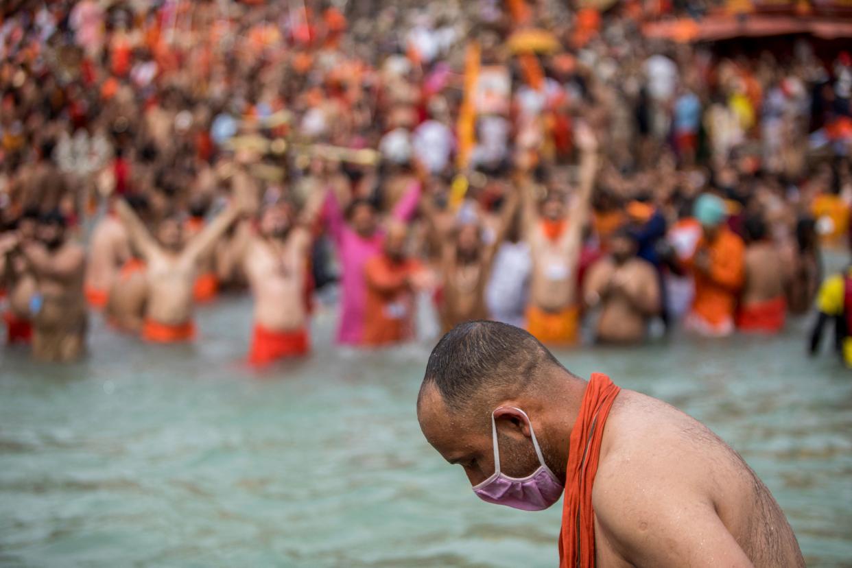 TOPSHOT - A Sadhu wearing a facemask takes a holy dip in the Ganges river during the ongoing religious Kumbh Mela festival in Haridwar on April 12, 2021. (Photo by Xavier GALIANA / AFP) (Photo by XAVIER GALIANA/AFP via Getty Images)