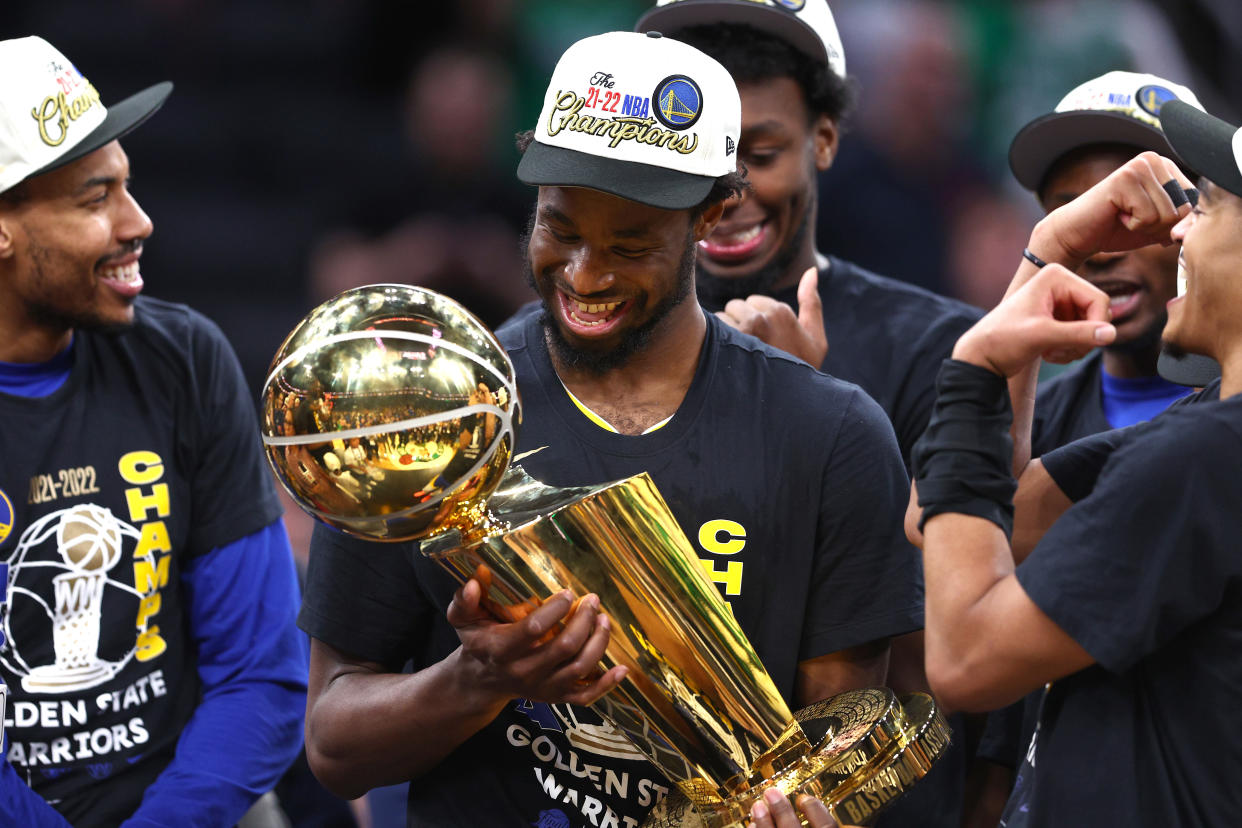 BOSTON, MASSACHUSETTS - JUNE 16: Andrew Wiggins #22 of the Golden State Warriors celebrates with th Larry O'Brien Championship Trophy after defeating the Boston Celtics 103-90 in Game Six of the 2022 NBA Finals at TD Garden on June 16, 2022 in Boston, Massachusetts. NOTE TO USER: User expressly acknowledges and agrees that, by downloading and/or using this photograph, User is consenting to the terms and conditions of the Getty Images License Agreement. (Photo by Elsa/Getty Images)