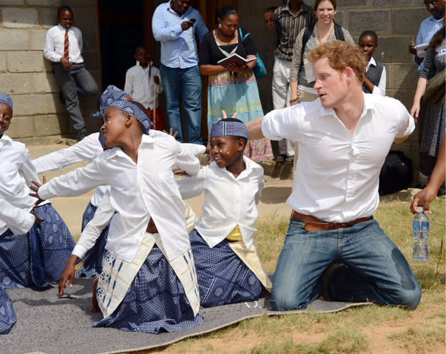 �Prince Harry enthusiastically performs a dance on his knees with children at the Kananelo Centre for the Deaf (Tim Rooke/Rex Features)