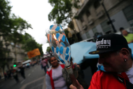 A man holds a candle during a protest against a cost increase in public and utility services in Buenos Aires, Argentina, January 10, 2019. REUTERS/Marcos Brindicci