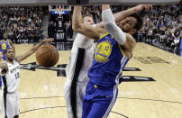 Golden State Warriors center Andrew Bogut (12) is hit across the face as he scores against San Antonio Spurs center Jakob Poeltl (25) during the first half of an NBA basketball game in San Antonio, Monday, March 18, 2019. (AP Photo/Eric Gay)