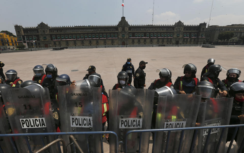 Police in riot gear block demonstrators who are demanding the resignation of Mexican President Andrés Manuel López Obrador, commonly known by his initials AMLO, from entering Mexico City's main square the Zocalo, Wednesday, Sept. 23, 2020. (AP Photo/Marco Ugarte)