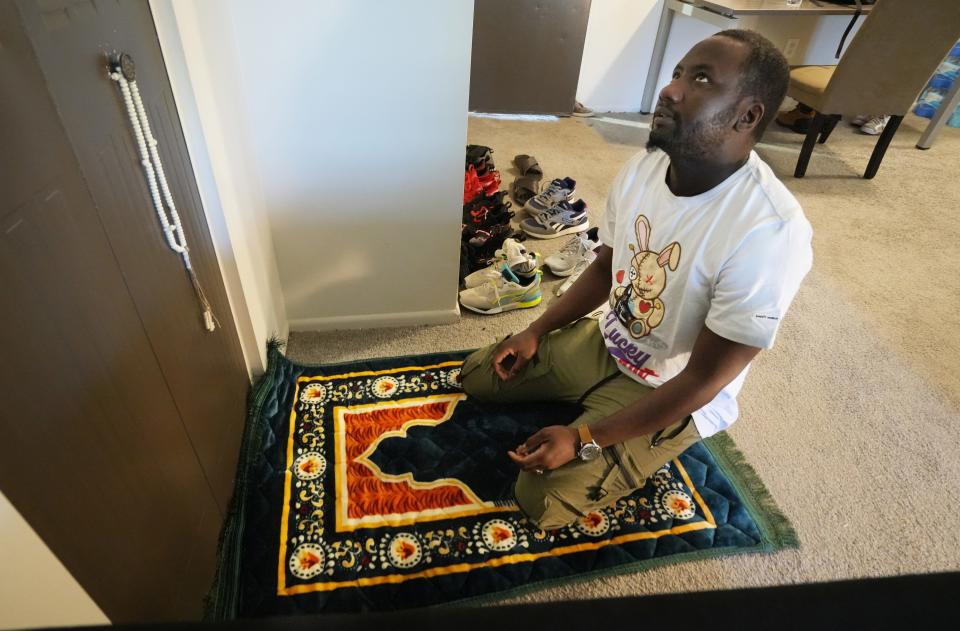 Amadou Kane, an asylum seeker from Mauritania, prays in his Southeast Side living room in March 2023. Kane said he had been enslaved in Mauritania before fleeing to the Ivory Coast, and eventually the U.S.