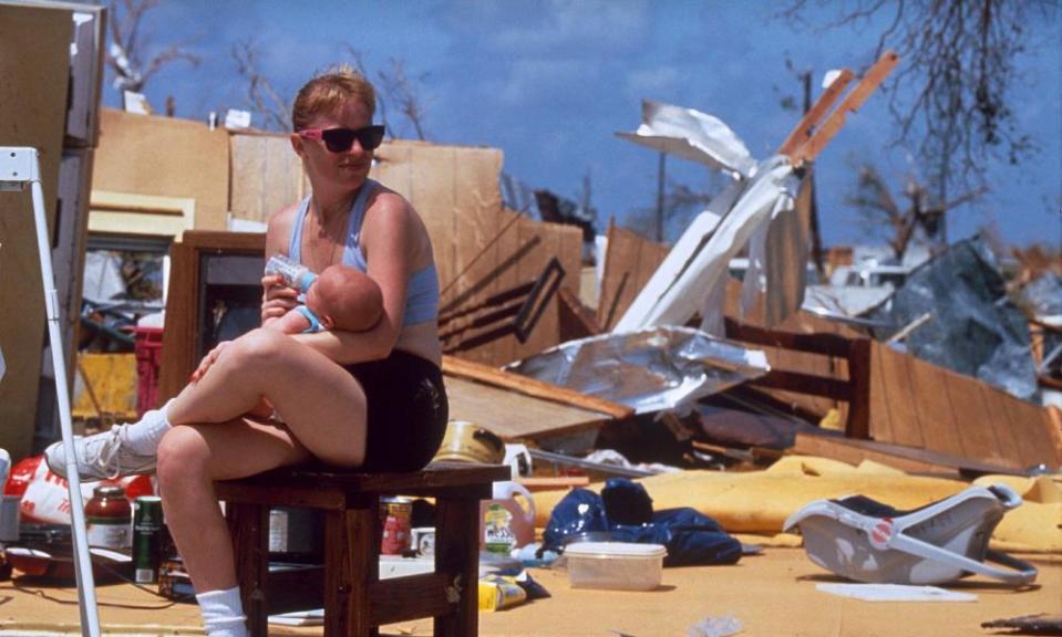A woman feeds a baby outside the wreckage of a house following Hurricane Andrew in Florida, 1992.