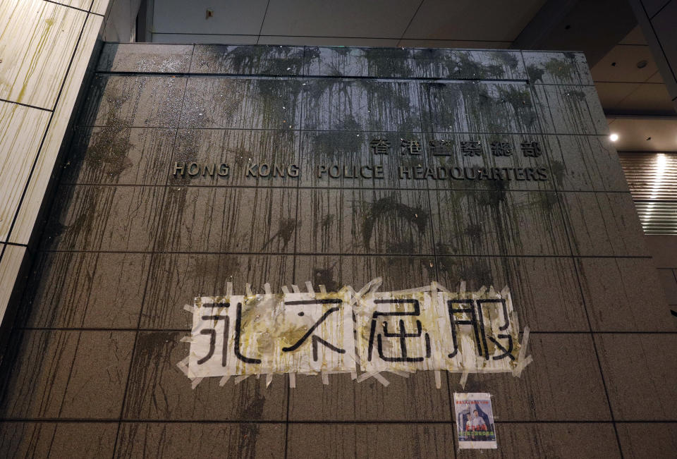 Eggs thrown by protestors are splattered on a wall with a banner "Never Give In" at the police headquarters in Hong Kong, Friday, June 21, 2019. More than 1,000 protesters blocked Hong Kong police headquarters into the evening Friday, while others took over major streets as the tumult over the city's future showed no signs of abating. (AP Photo/Vincent Yu)