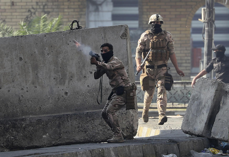 Riot police fire tear gas and smoke bombs during clashes between Iraqi security forces and anti-government protesters in Baghdad, Iraq, Monday, Nov. 11, 2019. (AP Photo/Hadi Mizban)