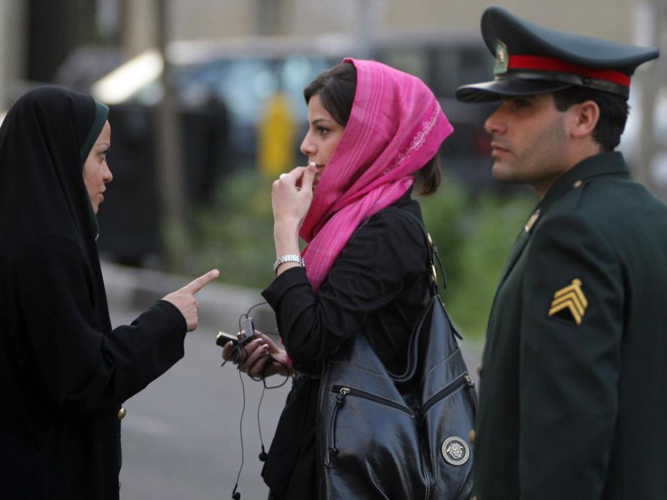 An Iranian policewoman (L) warns a woman about her clothing and hair during a crackdown to enforce Islamic dress code on April 22, 2007 in Tehran, Iran (Getty Images)