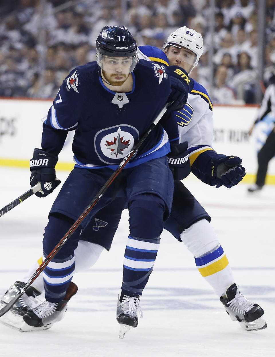 Winnipeg Jets center Adam Lowry (17) gets around St. Louis Blues center Ivan Barbashev (49). (John Woods/The Canadian Press via AP)