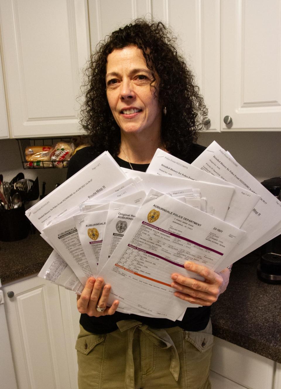 Tina Murray of Auburndale holds copies of records from police complaints she and her son have made against their neighbors on Pine Street. Murray lives with her adult son, John Murray, and they say their neighbors have engaged in a harassment campaign against them since March.