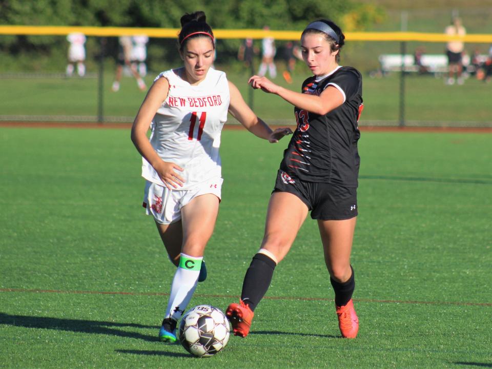 Taunton's Emily Calderon dribbles the ball under pressure from New Bedford's Ollie Costa during a non-league game.