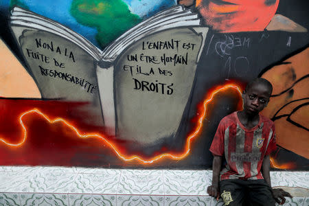 A Koran student, called a talibe, waits to receive his daily evening sandwich at Maison de la Gare, an organisation that helps talibe street children reintegrate into society, in Saint-Louis, Senegal, February 7, 2019. The writing on the wall reads: "No to running away from responsibility, the child is a human being and has rights." REUTERS/Zohra Bensemra