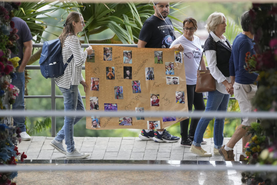 Relatives and friends carry a poster with photos of four-year-old Bernardo Pabst, who was killed by a man with a hatchet inside a day care center, during his funeral at the Sao Jose cemetery, in Blumenau, Santa Catarina state, Brazil, Thursday, April 6, 2023. A man with a hatchet jumped over a wall and burst into a day care center Wednesday in Brazil, killing four children, authorities said. (AP Photo/Andre Penner)