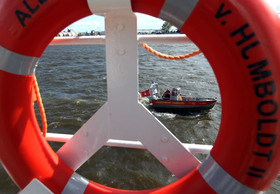 A fire department rescue boat is seen through a life preserver of the German ship Alexander von Humboldt II.