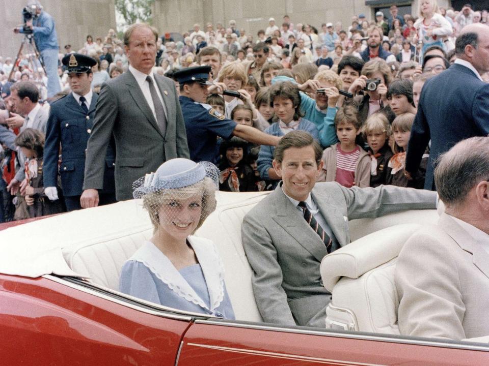 Diana, Princess of Wales, and Prince Charles sit in their car as a large crowd looks on during their visit to Stirling Oval, Canberra, Australia, March 26, 1983. (AP Photo/Dave Caulkin)