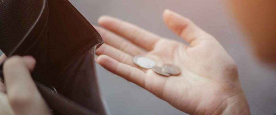 Person holding change from an empty wallet