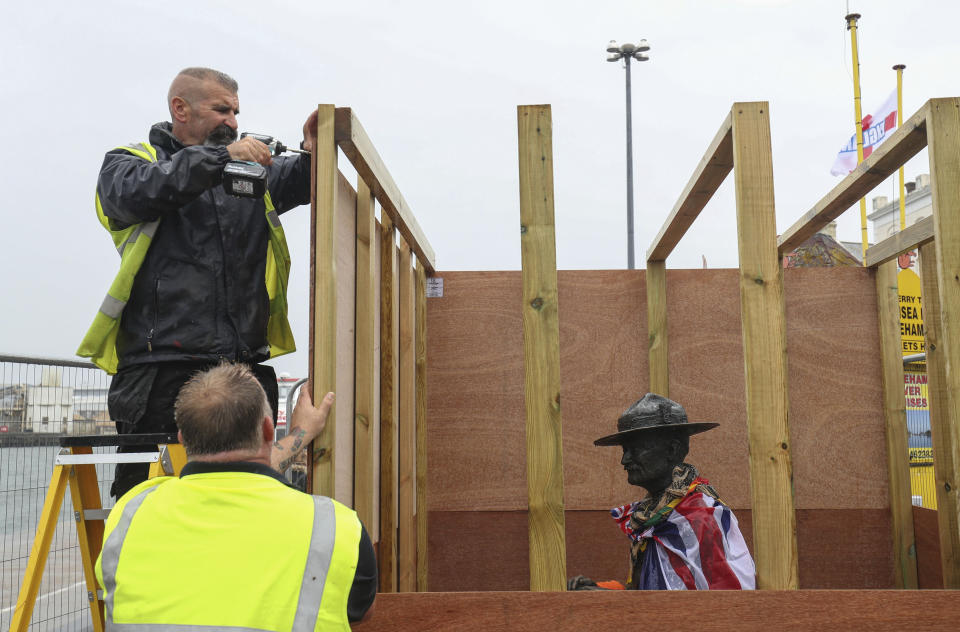 The statue of the Scouting Movement Robert Baden-Powell is boarded up by the local council, in Poole Quay, England, Friday June 12, 2020. The council has announced that the statue of Baden-Powell would be temporarily taken down as it is believed to be a target for protests. In the UK the Black Lives Matter movement has prompted a wider debate about issues relating to Britain's colonial past and historical figures. (Andrew Matthews/PA via AP)