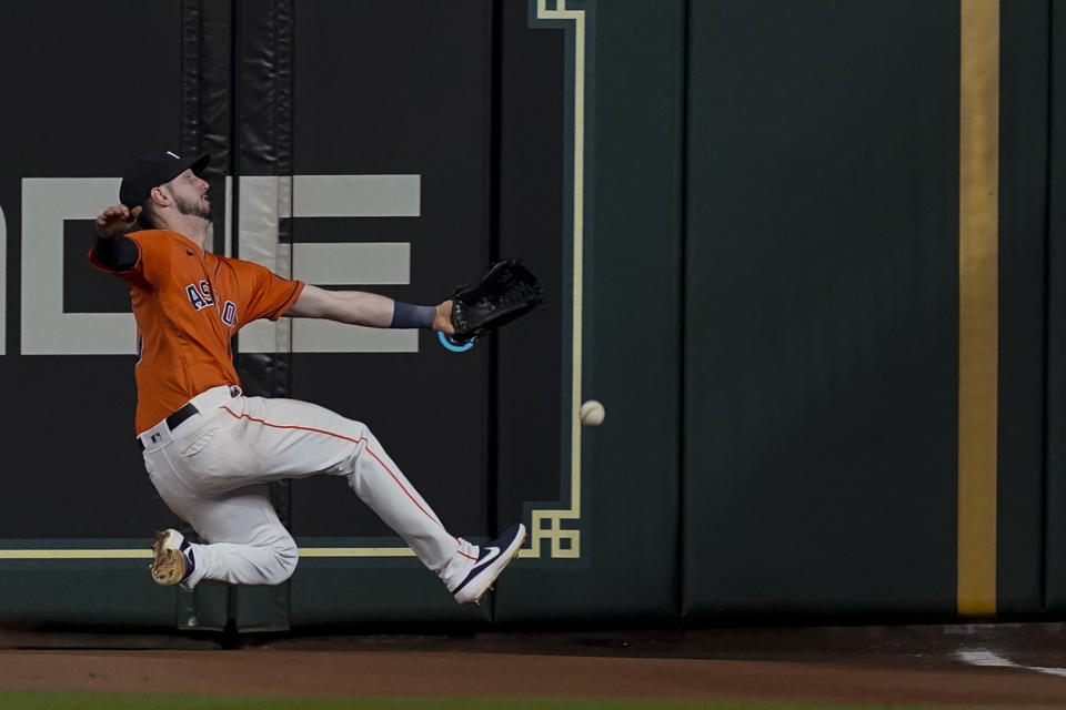 Houston Astros right fielder Kyle Tucker can't get a glove on a double by Boston Red Sox's Xander Bogaerts during the ninth inning in Game 2 of baseball's American League Championship Series Saturday, Oct. 16, 2021, in Houston. (AP Photo/Tony Gutierrez)