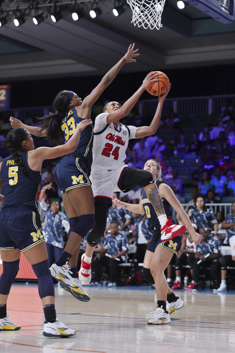 Mississippi's Madison Scott (24) drives to the basket as Michigan's Taylor Williams (33) defends and Michigan's Laila Phelia (5) and Elissa Brett (0) look on during an NCAA college basketball game in the Battle 4 Atlantis at Paradise Island, Bahamas, Monday, Nov. 20, 2023. (Tim Aylen/Bahamas Visual Services via AP)