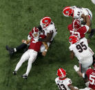 Georgia Bulldogs defensive lineman Jordan Davis (99) strips the ball from Alabama Crimson Tide quarterback Bryce Young (9) in the first quarter. Georgia recovered and appeared to score but it was ruled an incomplete pass at the 2022 College Football Playoff National Championship between the Georgia Bulldogs and the Alabama Crimson Tide at Lucas Oil Stadium in Indianapolis on Monday, January 10, 2022. (Bob Andres/Atlanta Journal-Constitution via AP)