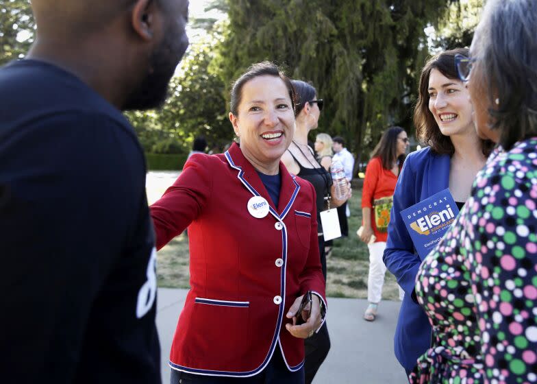 Eleni Kounalakis, second from left, smiles as she speaks to a small group of people.