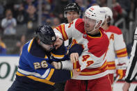 St. Louis Blues' Nathan Walker (26) and Calgary Flames' Joel Hanley (44) fight during the second period of an NHL hockey game Thursday, March 28, 2024, in St. Louis. (AP Photo/Jeff Roberson)