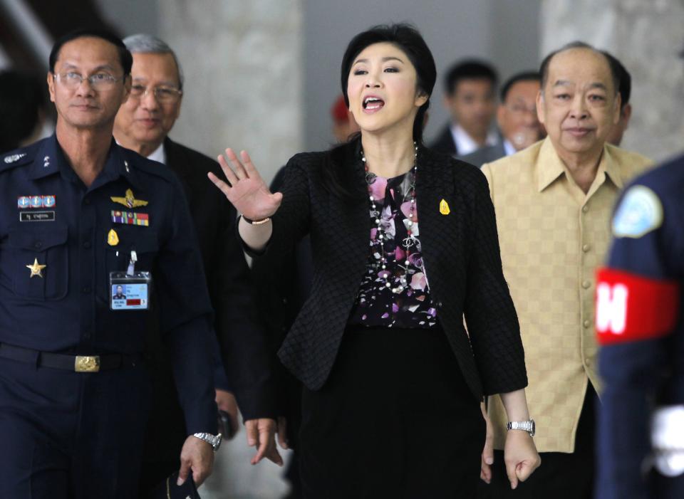 Thailand's Prime Minister Yingluck Shinawatra gestures as she leaves the Royal Thai Air Force Headquarters, after a cabinet meeting in Bangkok January 23, 2014. Thailand's Constitutional Court said it would decide on Thursday whether to accept a case against holding the February 2 election that would almost certainly extend the government's shaky grip on power as protesters try to force it from office. REUTERS/Chaiwat Subprasom (THAILAND - Tags: POLITICS CIVIL UNREST)