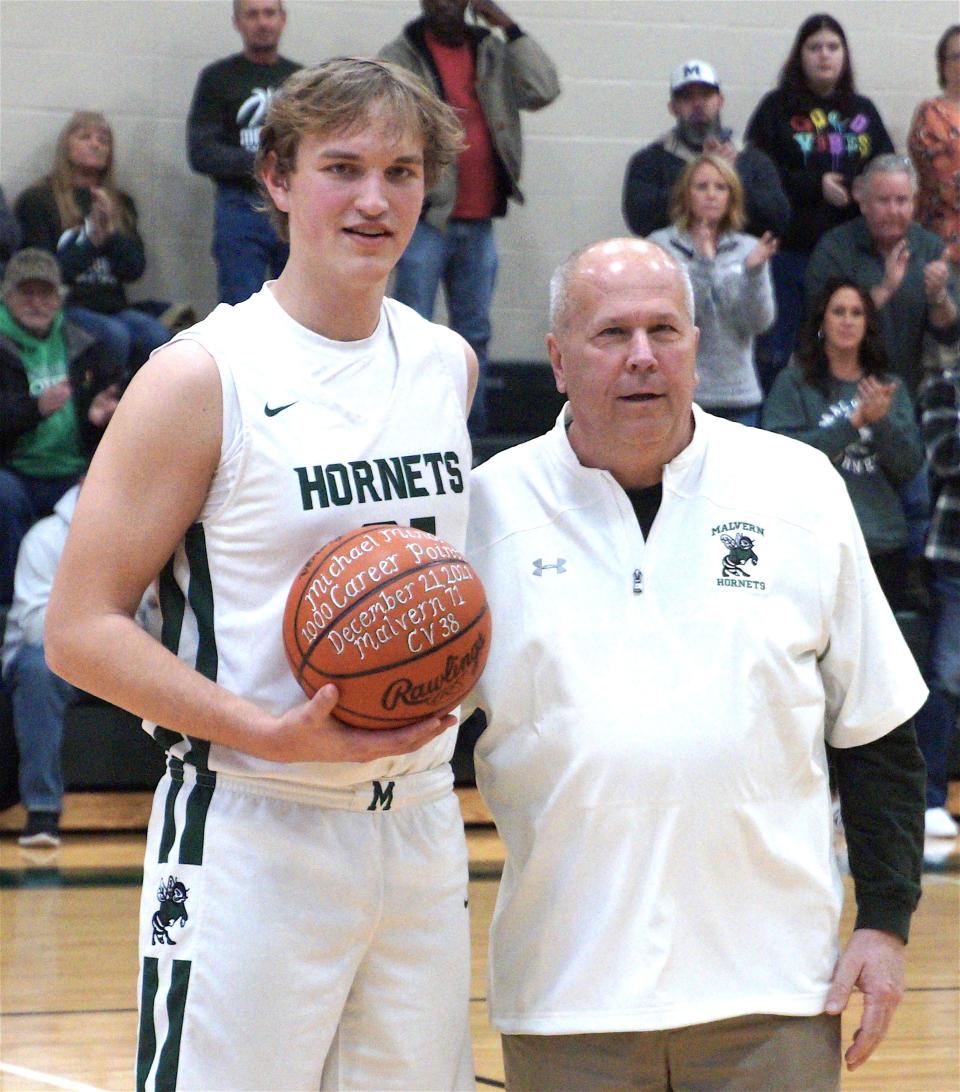 Michael Minor receives his 1,000-point ball from Head Coach Dennis Tucci prior to Malvern’s game against Newcomerstown.