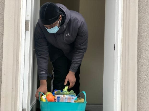 Shomari Mabayeke looks through a basket of groceries delivered to him by StepsStones for Youth, a charity that helps young people transition out of the child-welfare system.