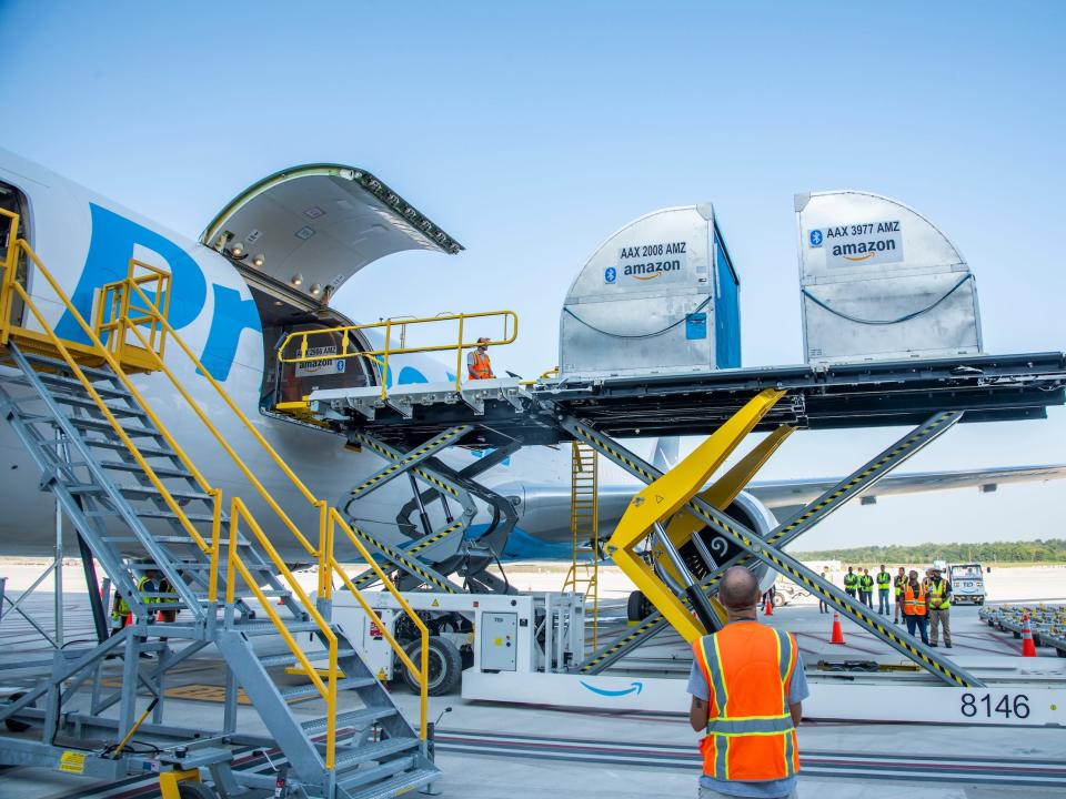 Amazon employees load cargo onto Amazon Air plane at new Kentucky hub