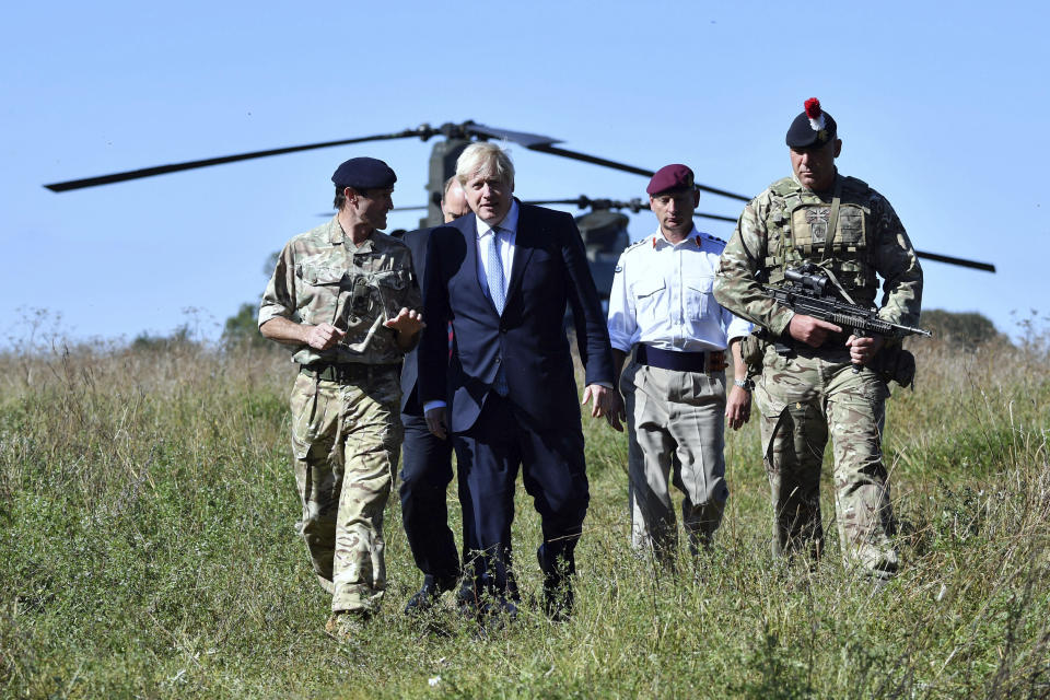 Britain's Prime Minister Boris Johnson arrives in a chinook helicopter to visit military personnel on Salisbury Plain training area near Salisbury, England, Thursday, Sept. 19, 2019. British Prime Minister Boris Johnson was accused by a one of the country’s former leaders of a “conspicuous” failure to explain why he suspended Parliament for five weeks, as a landmark Brexit case at the U.K. Supreme Court came to a head on Thursday. (Ben Stansall/Pool Photo via AP)