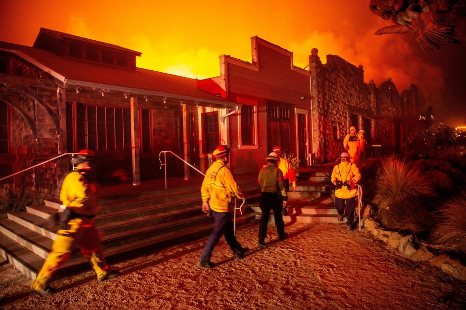 Firefighters survey the Soda Rock Winery as it burns during the Kincade fire as flames race through Healdsburg, California on October 27, 2019. - Powerful winds were fanning wildfires in northern California in "potentially historic fire" conditions, authorities said October 27, as tens of thousands of people were ordered to evacuate and sweeping power cuts began in the US state. (Photo by Josh Edelson / AFP) (Photo by JOSH EDELSON/AFP via Getty Images)