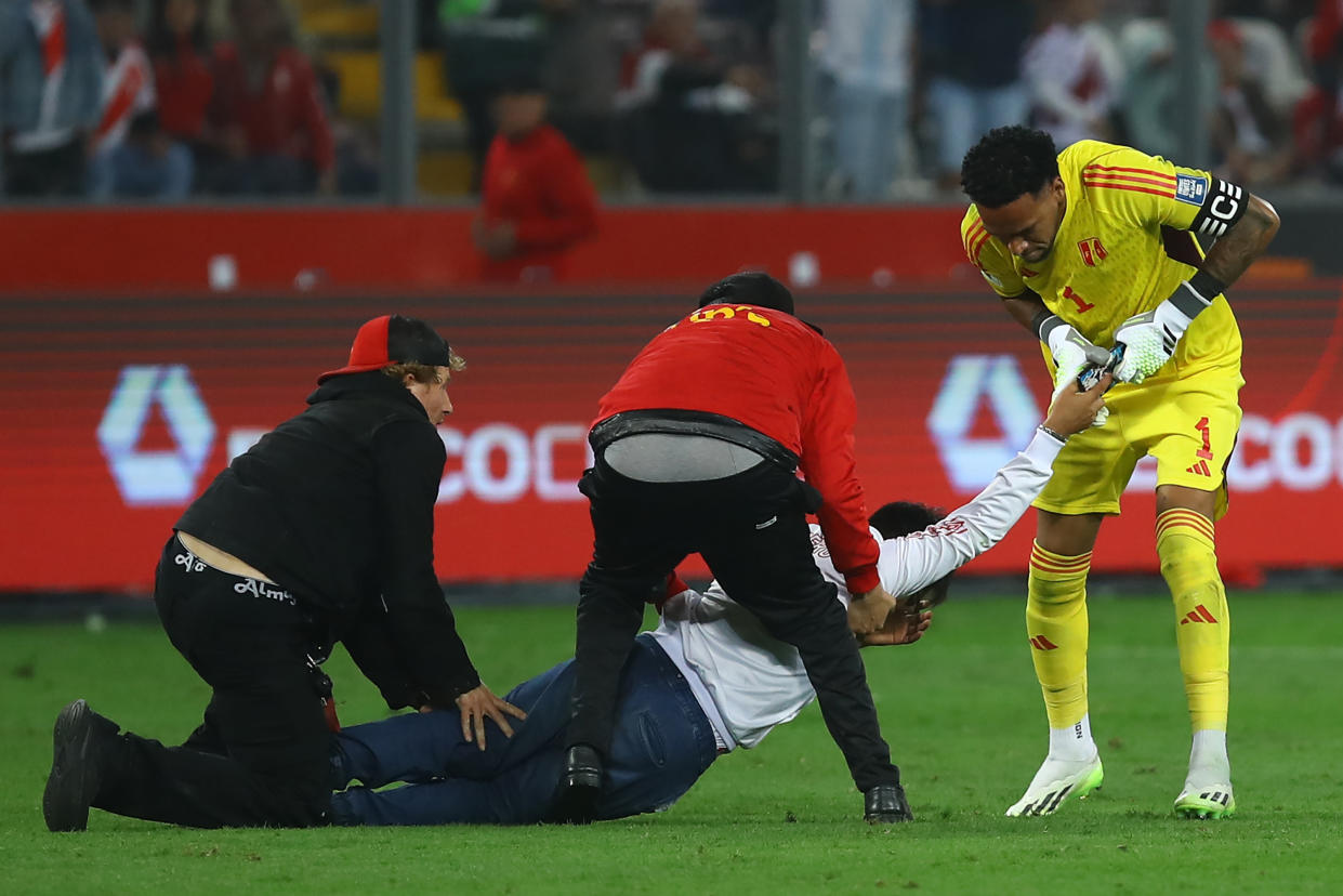 Pedro Gallese le arrebata el celular a fan peruano que se metió al campo del Estadio Nacional de Lima, para buscar foto con Messi, el pasado 17 de octubre. (Leonardo Fernandez/Getty Images)